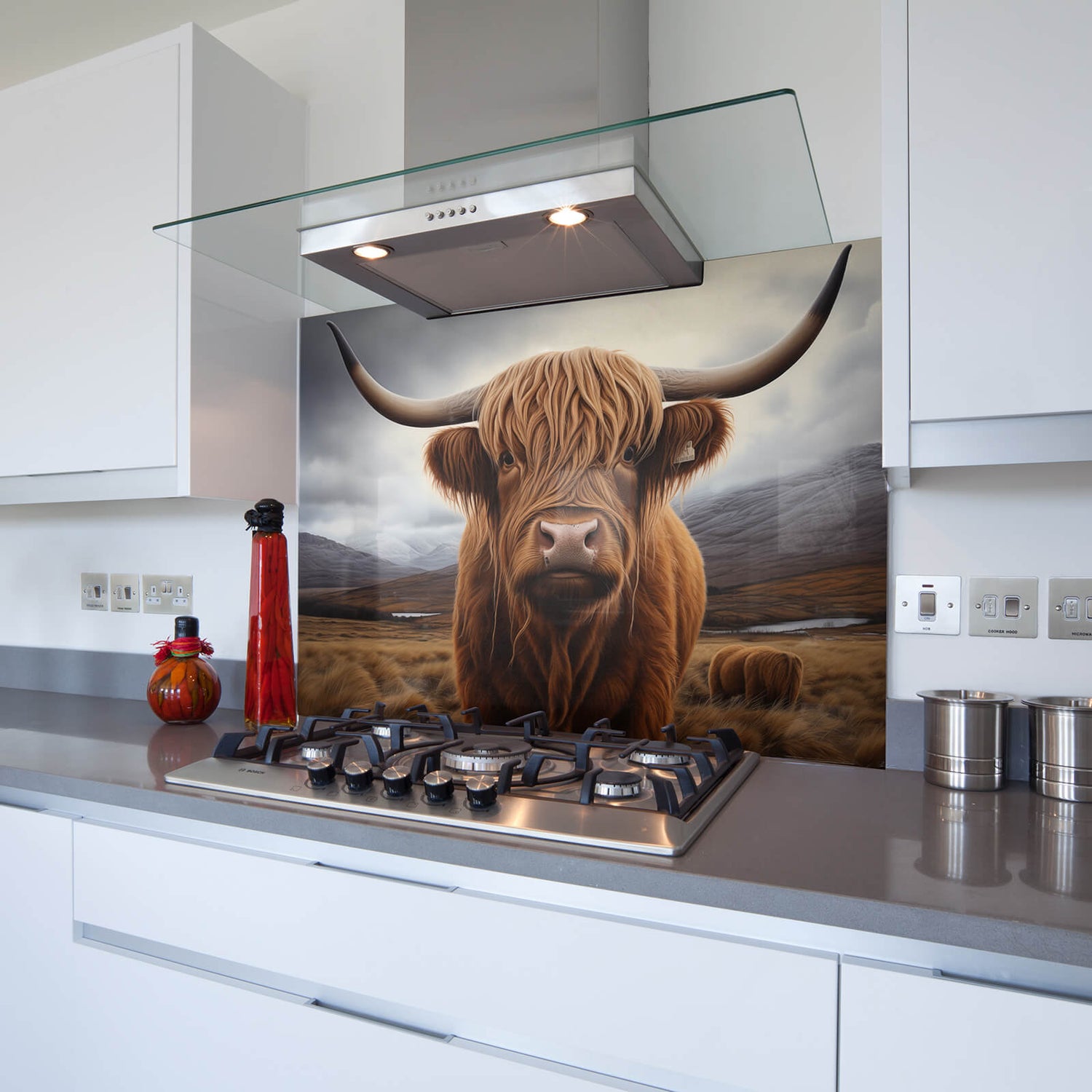 A highland cow splashback over a hob