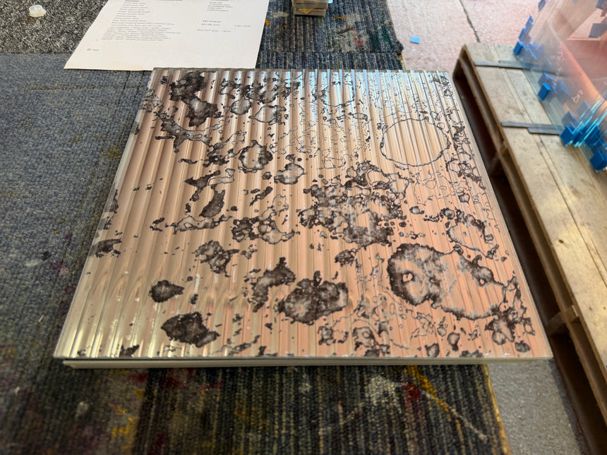 A top view of a reeded antique mirror splashback showing a rust pattern