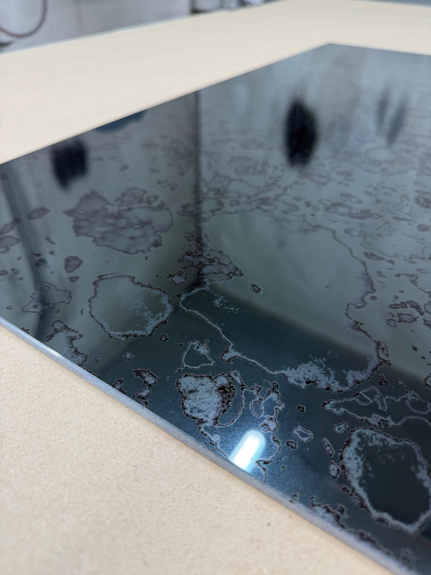 Close up from an angle of a toughened grey antique mirror splashback