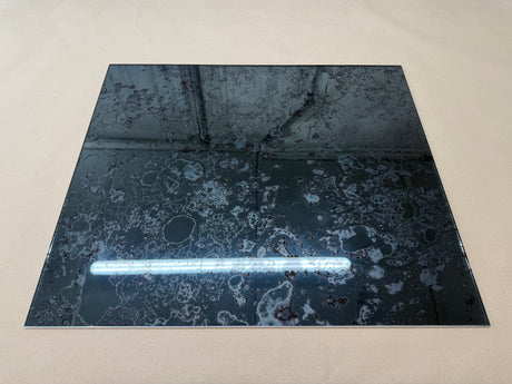 A dark grey antique mirror splashback with a rusted pattern on a white background