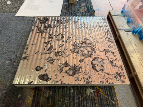 A top view of a reeded antique mirror splashback showing a rust pattern